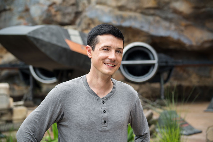 Matt Martin, Creative Executive of Franchise Story & Content from the Lucasfilm Story Group stands in front of Poe’s X-wing from Star Wars: Rise of the Resistance